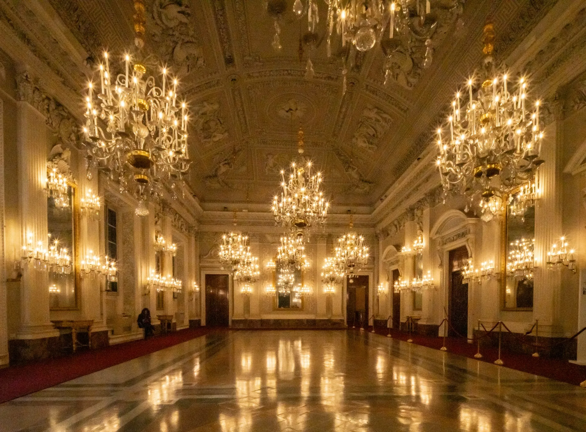 A grand ballroom lit by crystal chandeliers